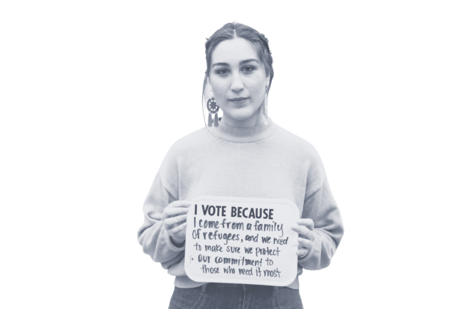 Woman holding sign explaining why she votes.